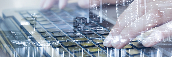 Closeup of fingers typing on a laptop keyboard with a cityscape superimposed on top of the image.